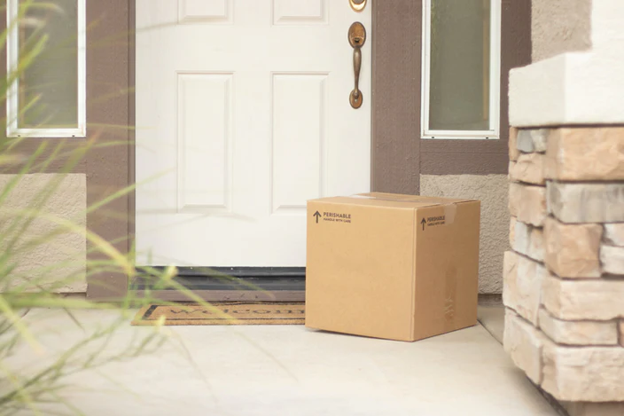 Package on doorstep with doorbell camera preventing package theft.